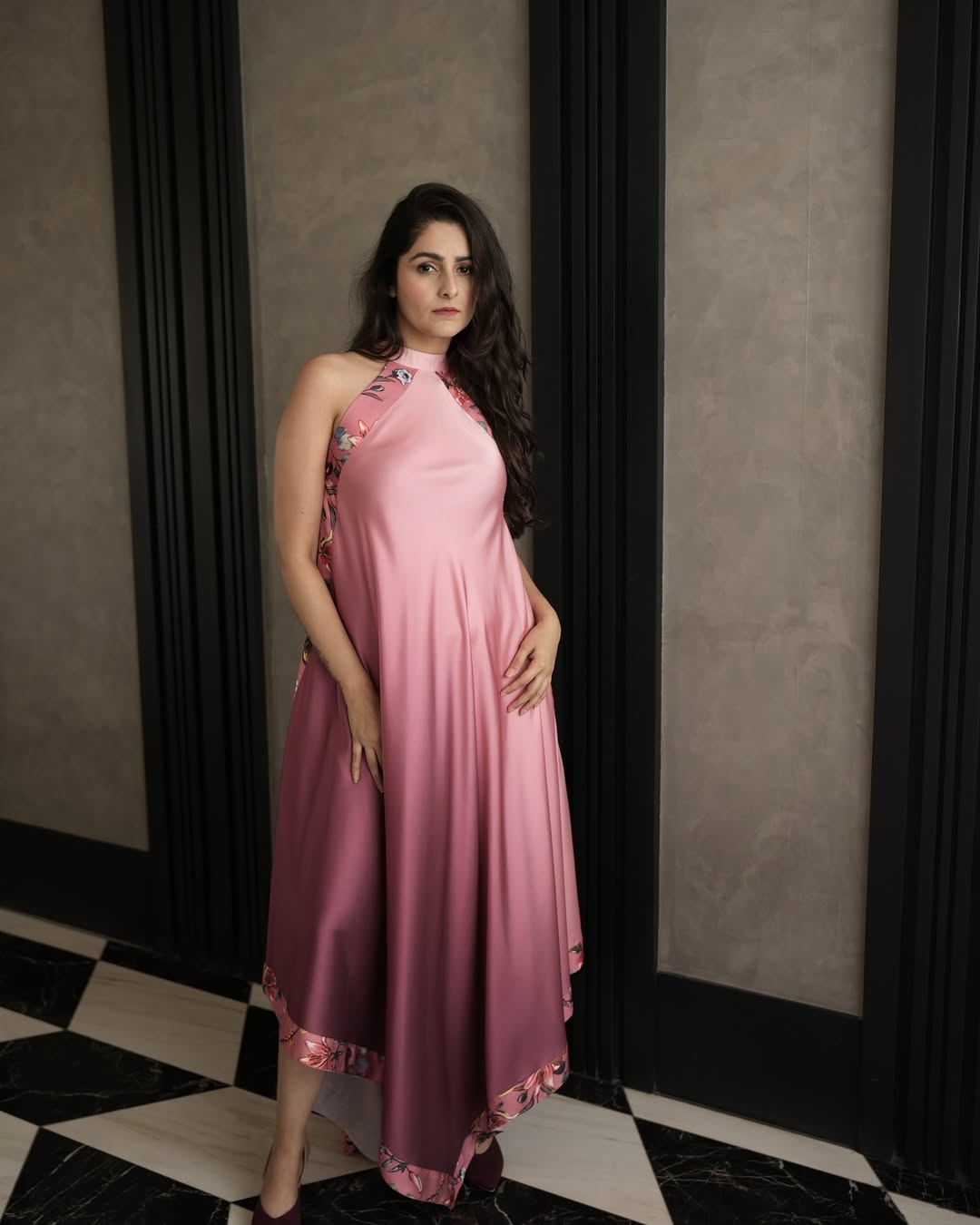 Model in a pink draped halter neck dress with floral edging – Prisella elegant occasionwear