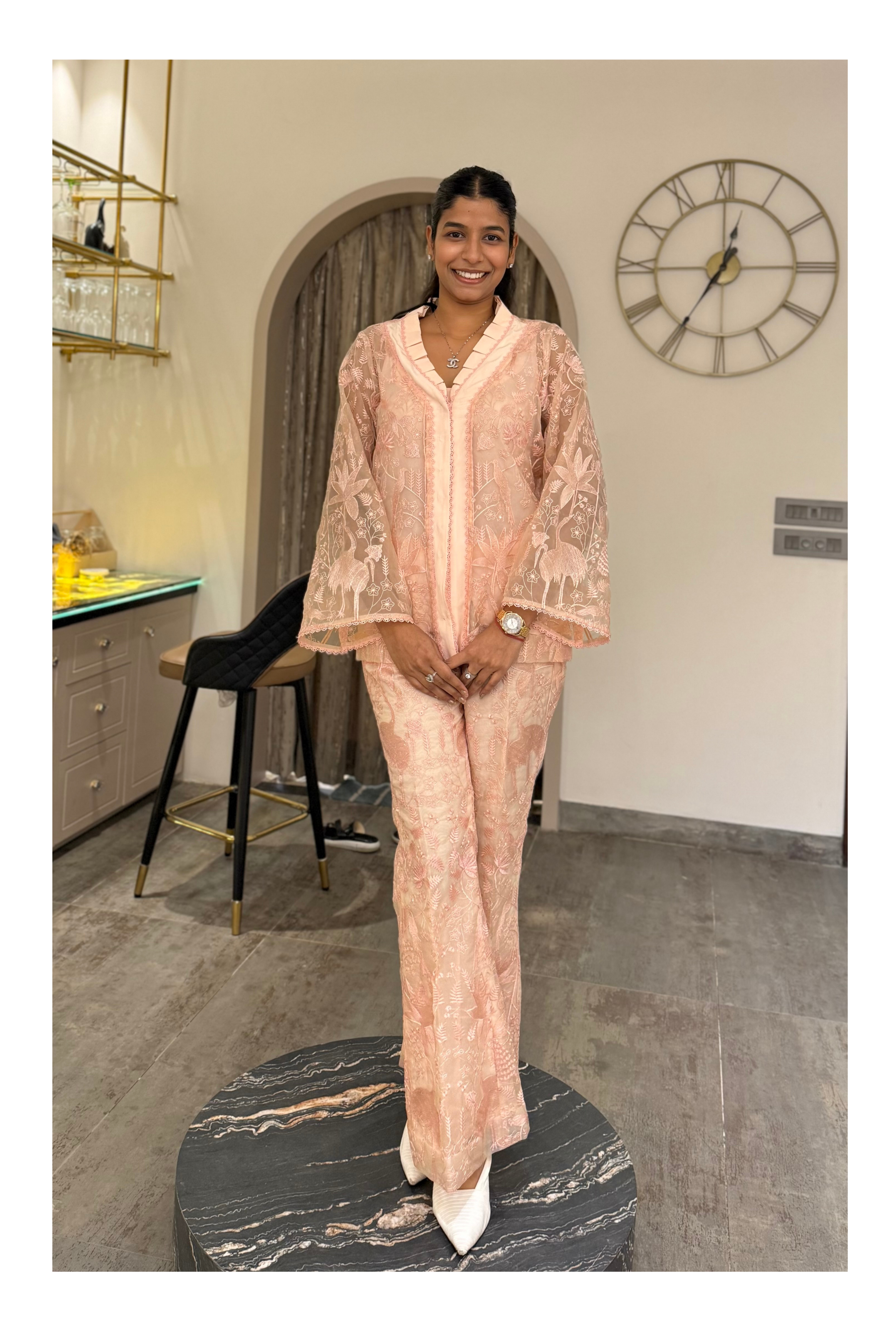 Model in a soft blush embroidered kurta set with sheer sleeves and wide-leg pants, styled for festive brunches and intimate celebrations.